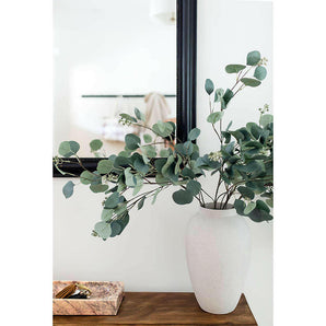 Tallo de eucalipto con monedas de plata falsas.