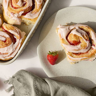 Freshly baked cinnamon rolls with a detailed recipe showcasing step-by-step preparation and ingredients for perfect results
