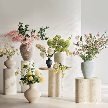 Crate & Barrel decorative vases with fresh spring flowers in neutral tones arranged on pedestals – home decor up to 20% off