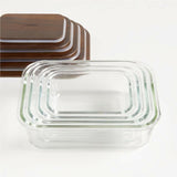Crate & Barrel 8-Piece Rectangular Glass Storage Containers with Dark Wood Lids.